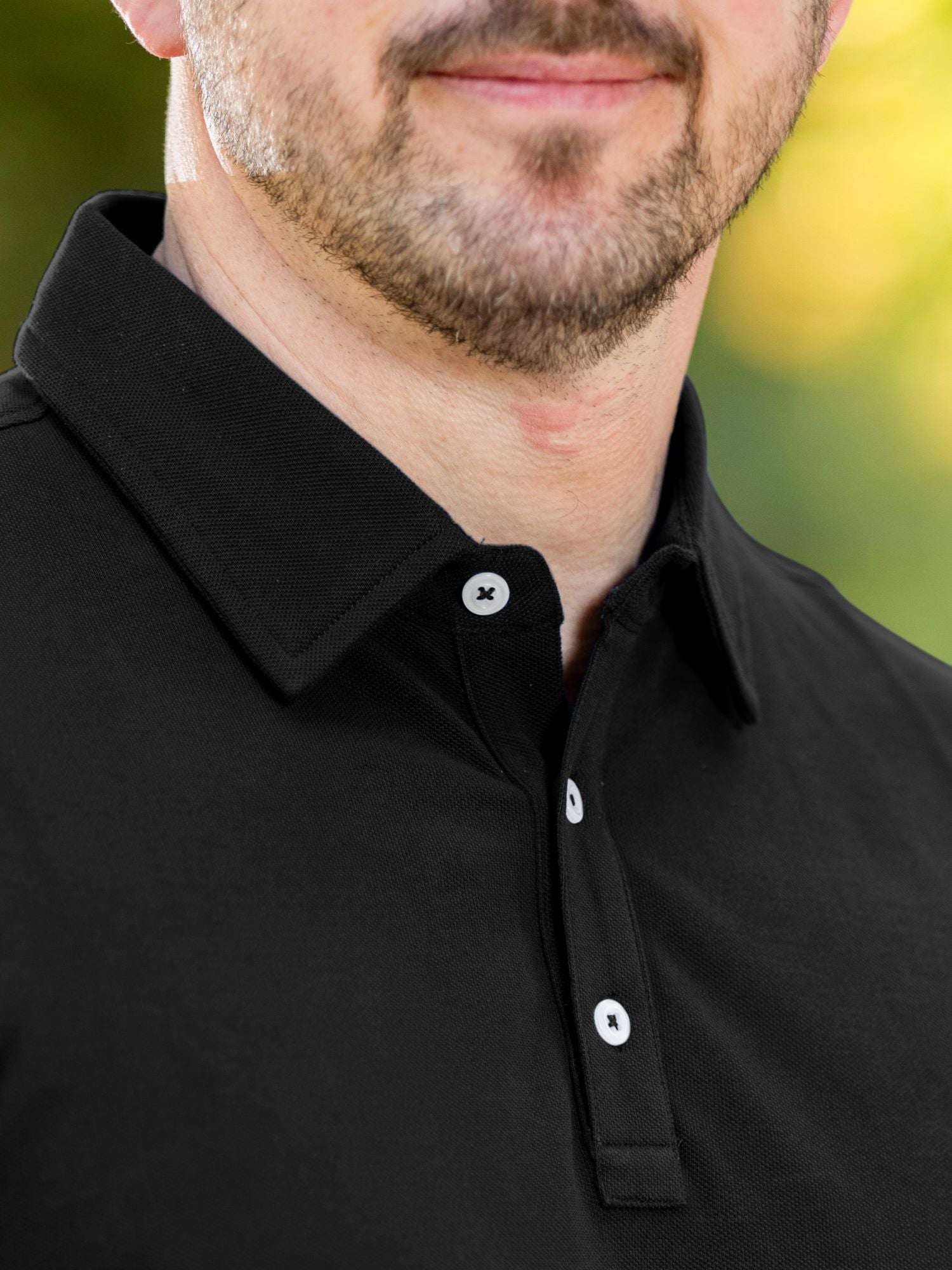 A close up of a stay-flat black tall polo collar.