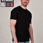 A tall and slim man in the studio standing in front of a light background. The smiling model is wearing an extra long slim black t-shirt in a size XL. The tall black t-shirt features a 3" longer body, 100% organic cotton, and is soft & preshrunk. The black t-shirt is ideal for tall slim men 6'2"+. Buy 2 Save 10%, Buy 4 Save 15%, Buy 6 Save 20%.