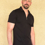 Man wearing an XL tallblack polo shirt against a beige background.