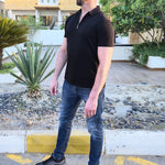 A head to toe shot of a tall slim man wearing an XL tall black zip polo shirt.