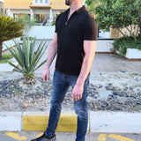 A head to toe shot of a tall slim man wearing an XL tall black zip polo shirt.