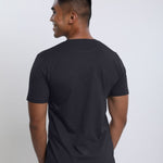 A shot from behind of a tall slim man wearing a charcoal medium tall t-shirt.