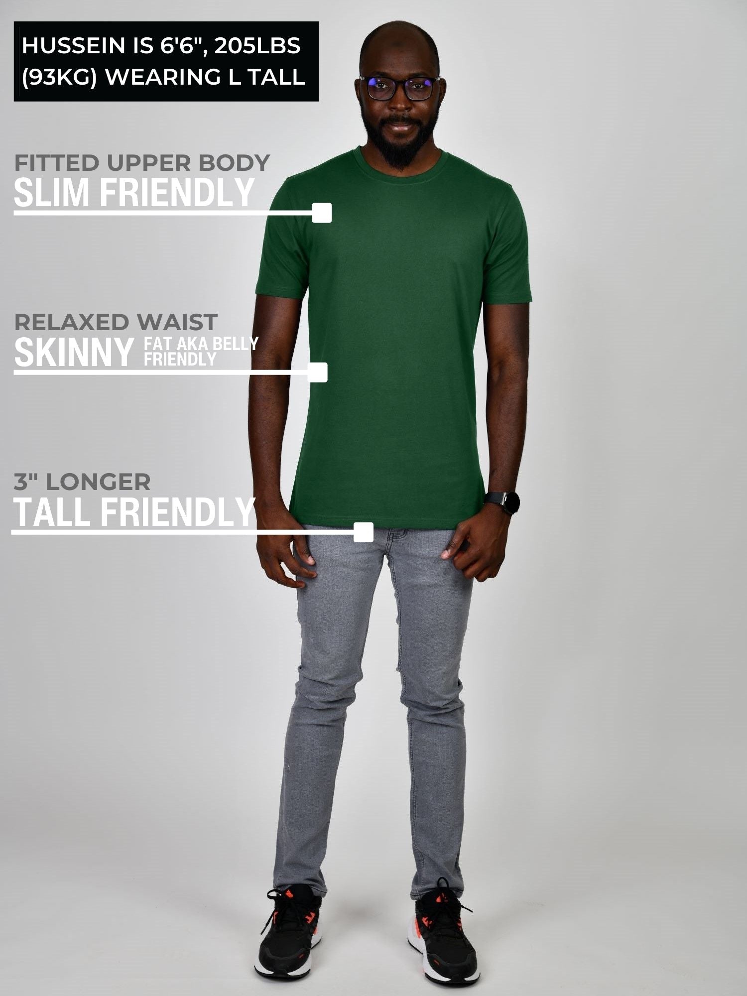 A head to toe shot of a tall athletic guy wearing a dark green large tall t-shirt.