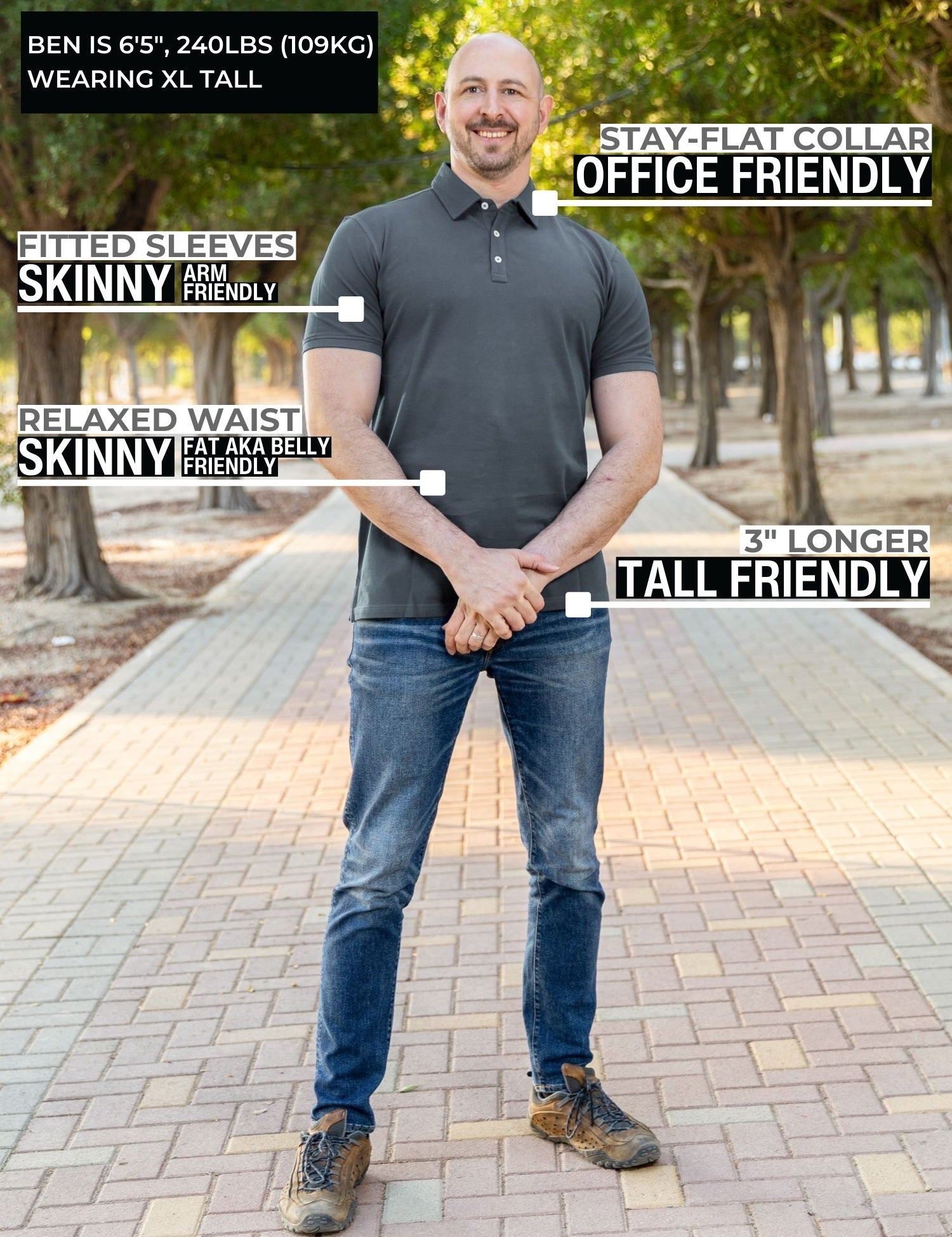 A head to toe shot of a tall athletic man in a park wearing a dark slate XL tall polo shirt and smiling.