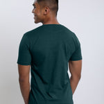 A shot from behind of a tall slim guy wearing a dark teal medium tall t-shirt.