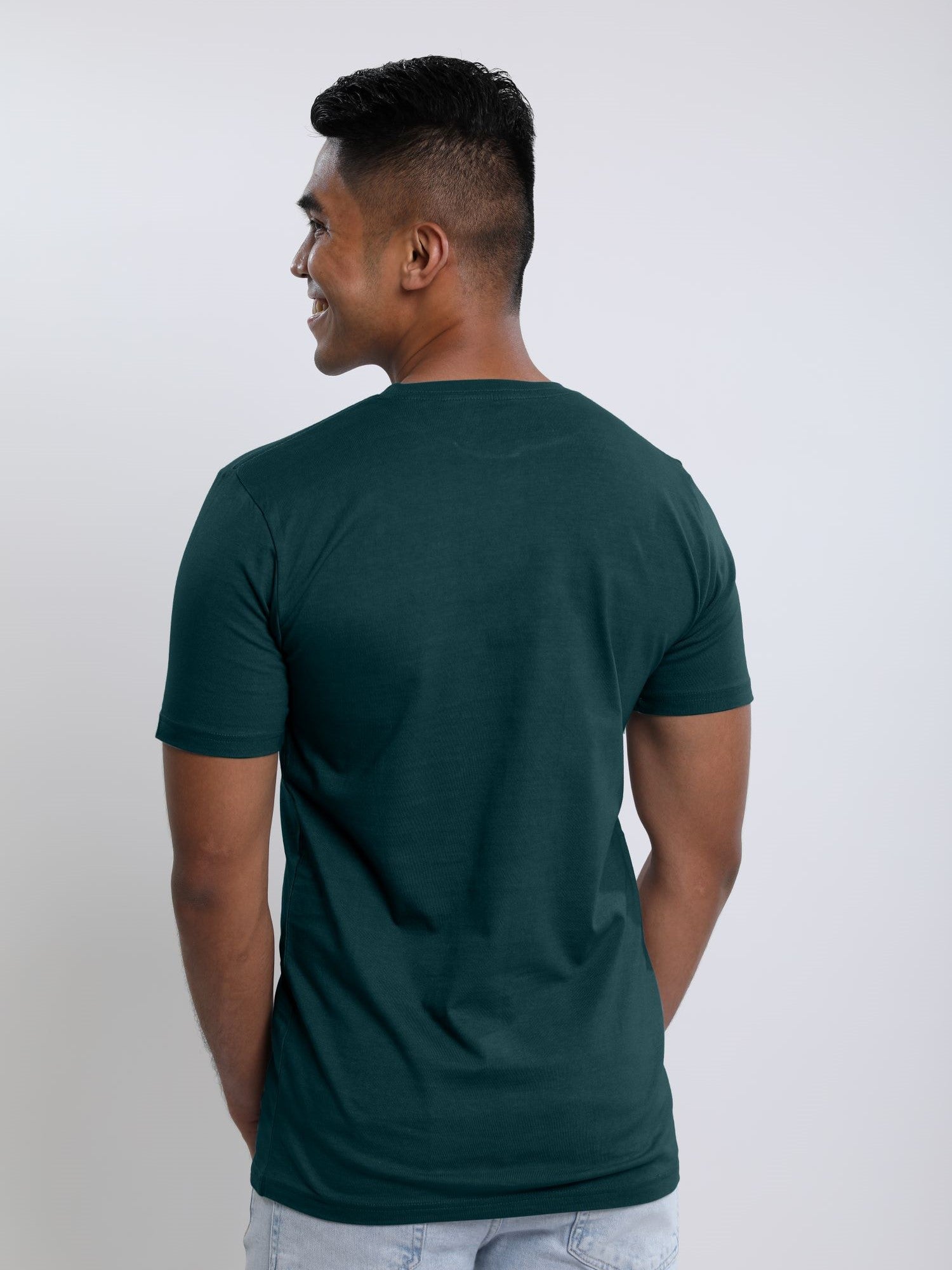 A shot from behind of a tall slim guy wearing a dark teal medium tall t-shirt.