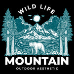 A bear in front of a lake with trees to either side and a mountain, sun and clouds in the background. With the text: Wildlife - Mountain Outdoor Aesthetic