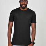 A tall slim guy wearing a large tall heavyweight black t-shirt, hands at his sides and smiling.