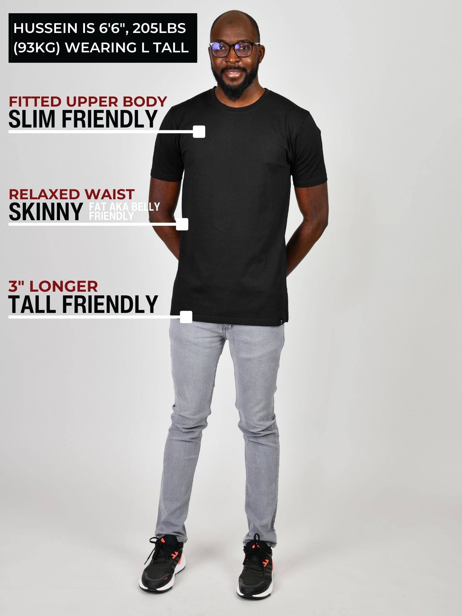 A head to toe shot of a tall slim guy wearing a large tall heavyweight black t-shirt.