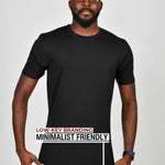 A tall slim guy wearing a large tall black heavyweight t-shirt, pulling gently down on the bottom seam to show the extra length.