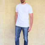 A head to toe shot of a tall slim guy wearing an XL tall white heavyweight t-shirt.