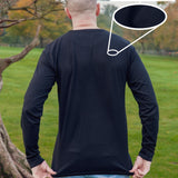 A shot from behind of a tall slim guy in a park wearing an extra long sleeve long sleeve tall t-shirt in black.