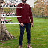 A head to toe shot of a tall athletic guy wearing an XL tall maroon long sleeve t-shirt, standing in a park and looking down at the Just Tall logo.