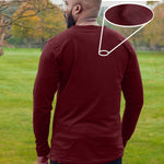 A shot from behind of a tall athletic guy wearing an XL tall maroon long sleeve t-shirt, standing in a park.