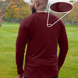 A shot from behind of a tall athletic guy wearing an XL tall maroon long sleeve t-shirt, standing in a park.