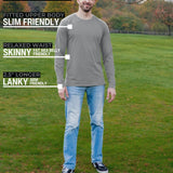 A head to toe shot of a tall athletic guy in a park wearing a light grey long sleeve tall t-shirt.