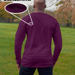 A shot from behind of a tall slim guy in a park wearing an extra long sleeve long sleeve tall t-shirt in dark purple.