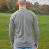 A shot from behind of a tall athletic guy wearing a long sleeve light grey tall t-shirt.