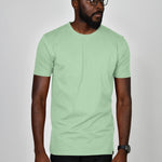 A studio shot of a tall slim guy wearing a large tall slim pastel green t-shirt.