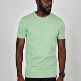 A studio shot of a tall slim guy wearing a large tall slim pastel green t-shirt.