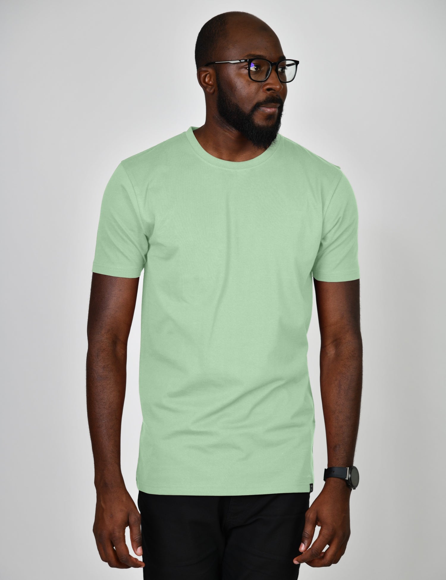 A studio shot of a tall slim guy wearing a large tall slim pastel green t-shirt.