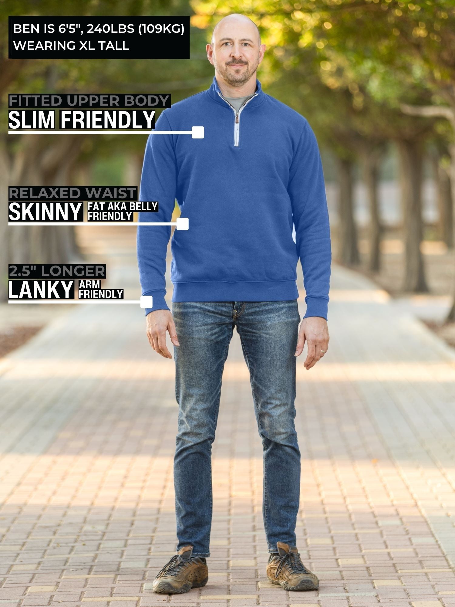 A head to toe shot of a tall slim guy in a park wearing an XL tall extra long cobalt quarter zip sweatshirt.