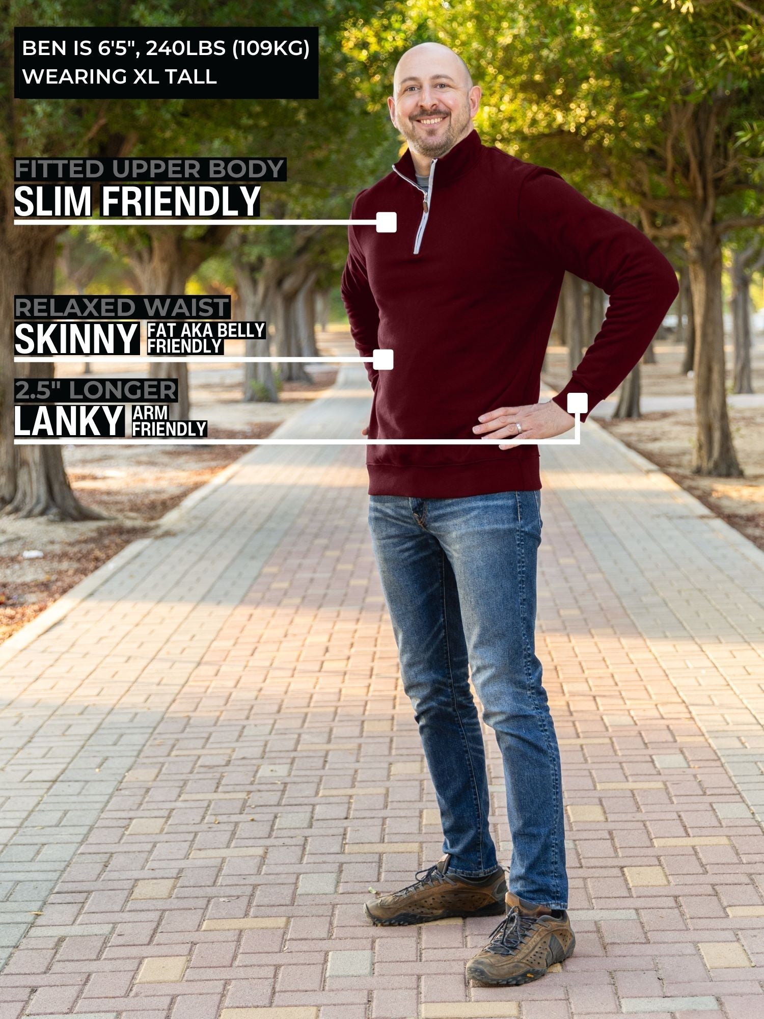 A head to toe shot of a tall slim guy in a park wearing an XL tall extra long maroon quarter zip sweatshirt.