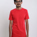 A tall and skinny man in the studio standing in front of a light background. The model is wearing an extra long slim red t-shirt. The red t-shirt features a 3" longer body, 100% organic cotton, and is soft & preshrunk. The red t-shirt is ideal for tall slim men 6'2"+.