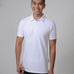 A tall and slim man in the studio standing in front of a light background. The smiling model is wearing an extra long slim white polo shirt in a size M. The tall white polo shirt features a 3" longer body, 100% organic cotton, and is soft & preshrunk. The white polo shirt is ideal for tall slim men 6'2"+.