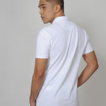 A shot from behind of a tall slim guy in a studio and wearing a white M tall polo shirt.