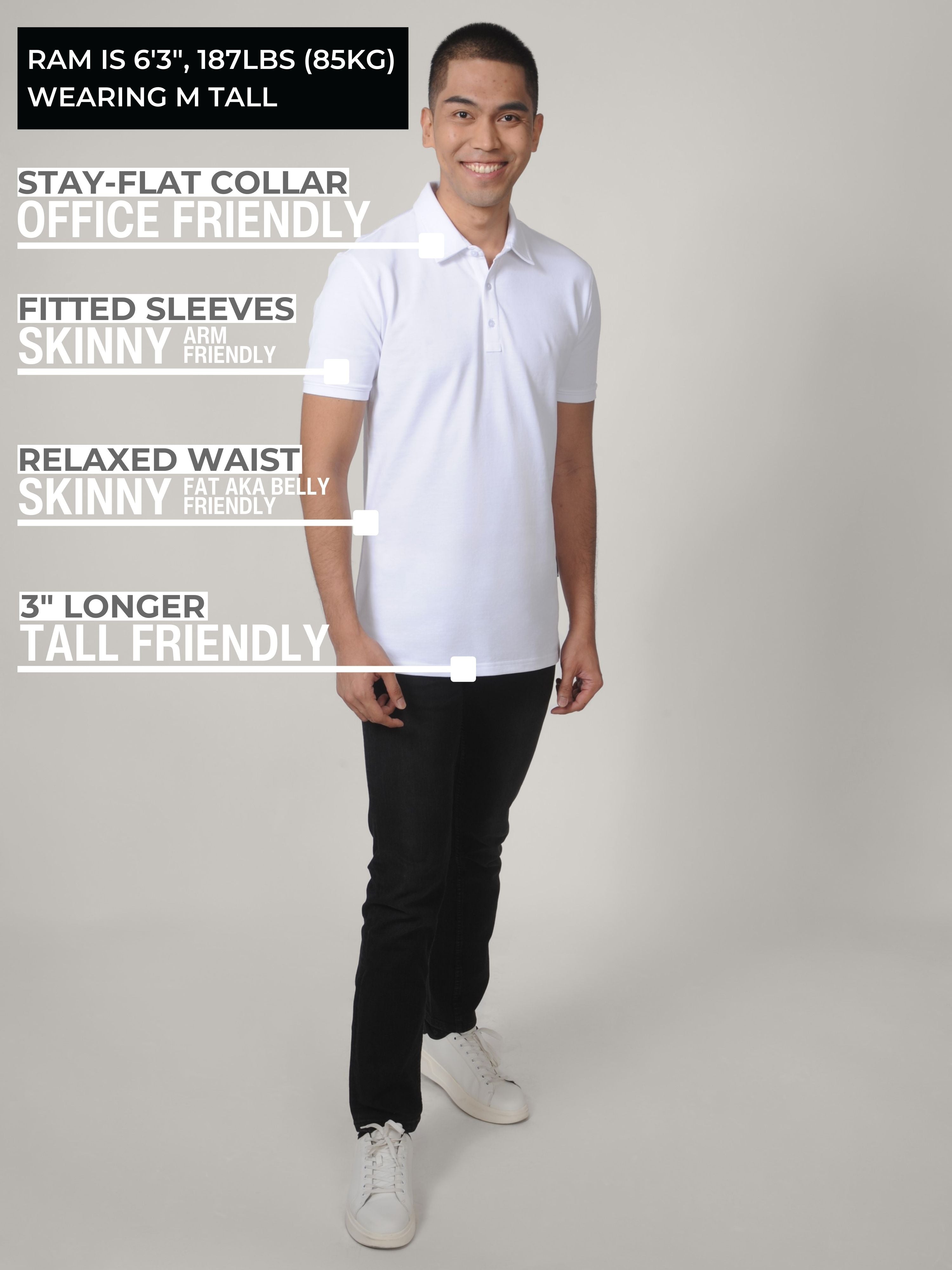 A head to toe shot of a tall slim man in a studio wearing a white M tall polo shirt and smiling.