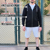 A head to toe shot of a tall slim guy standing in a tennis court, smiling and wearing an XL tall slim black zip up hoodie.