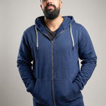 A tall and broad guy standing in a studio and wearing a 2XL Tall dark navy zip-up hoodie.