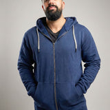 A tall and broad guy standing in a studio and wearing a 2XL Tall dark navy zip-up hoodie.