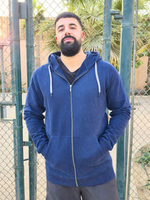 A tall and broad guy standing in a tennis court and wearing a 2XL Tall dark navy zip-up hoodie.