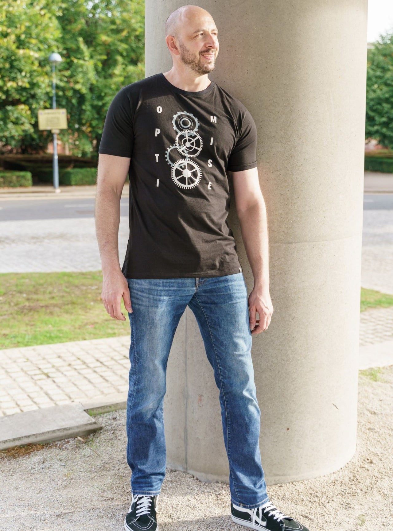 A head to toe shot of a tall skinny guy wearing a black tall slim t-shirt.