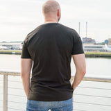 A shot from behind of a tall skinny guy wearing a tall black t-shirt
