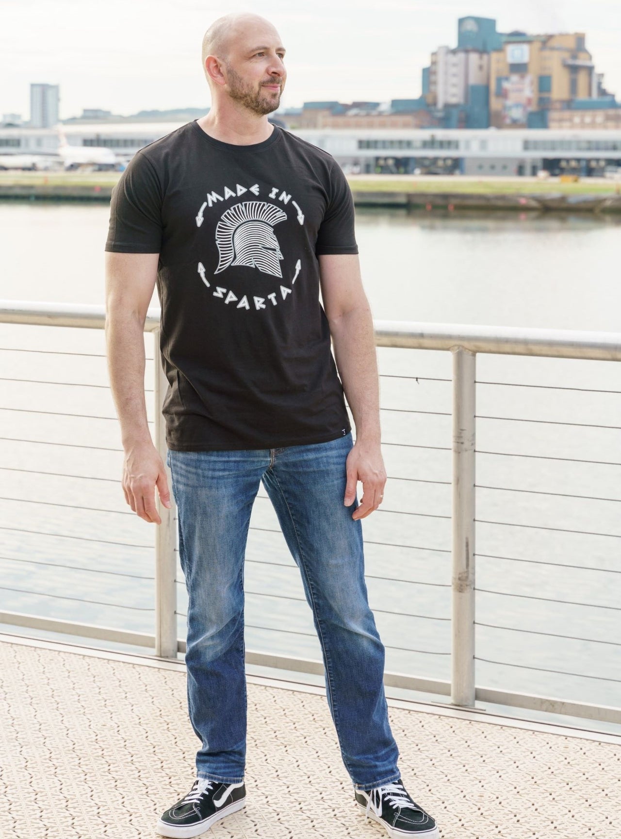 A head to toe shot of a tall skinny guy wearing a tall slim graphic t-shirt.