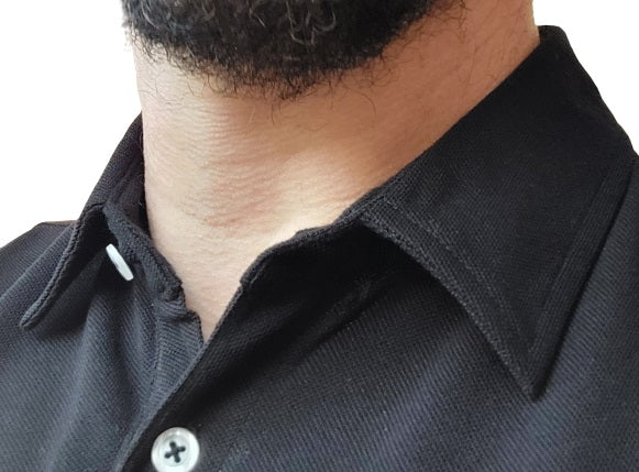Close up of a tall pique polo collar, semi-spread shirt style.