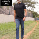 A head to toe shot of a tall skinny guy wearing a tall black henley shirt.