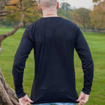 A shot from behind of a tall athletic guy wearing a long sleeve black tall t-shirt.