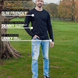 A head to toe shot of a tall athletic guy in a park wearing a black long sleeve tall t-shirt.