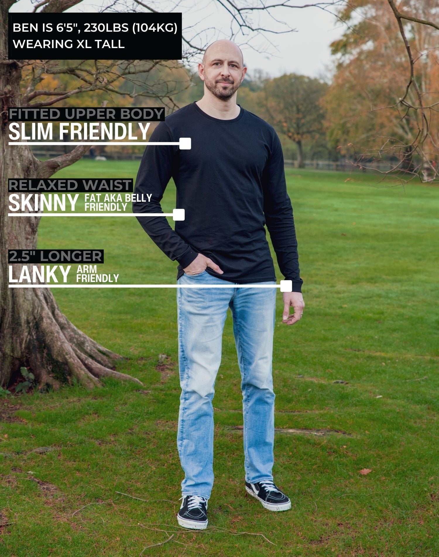 A head to toe shot of a tall athletic guy in a park wearing a black long sleeve tall t-shirt.