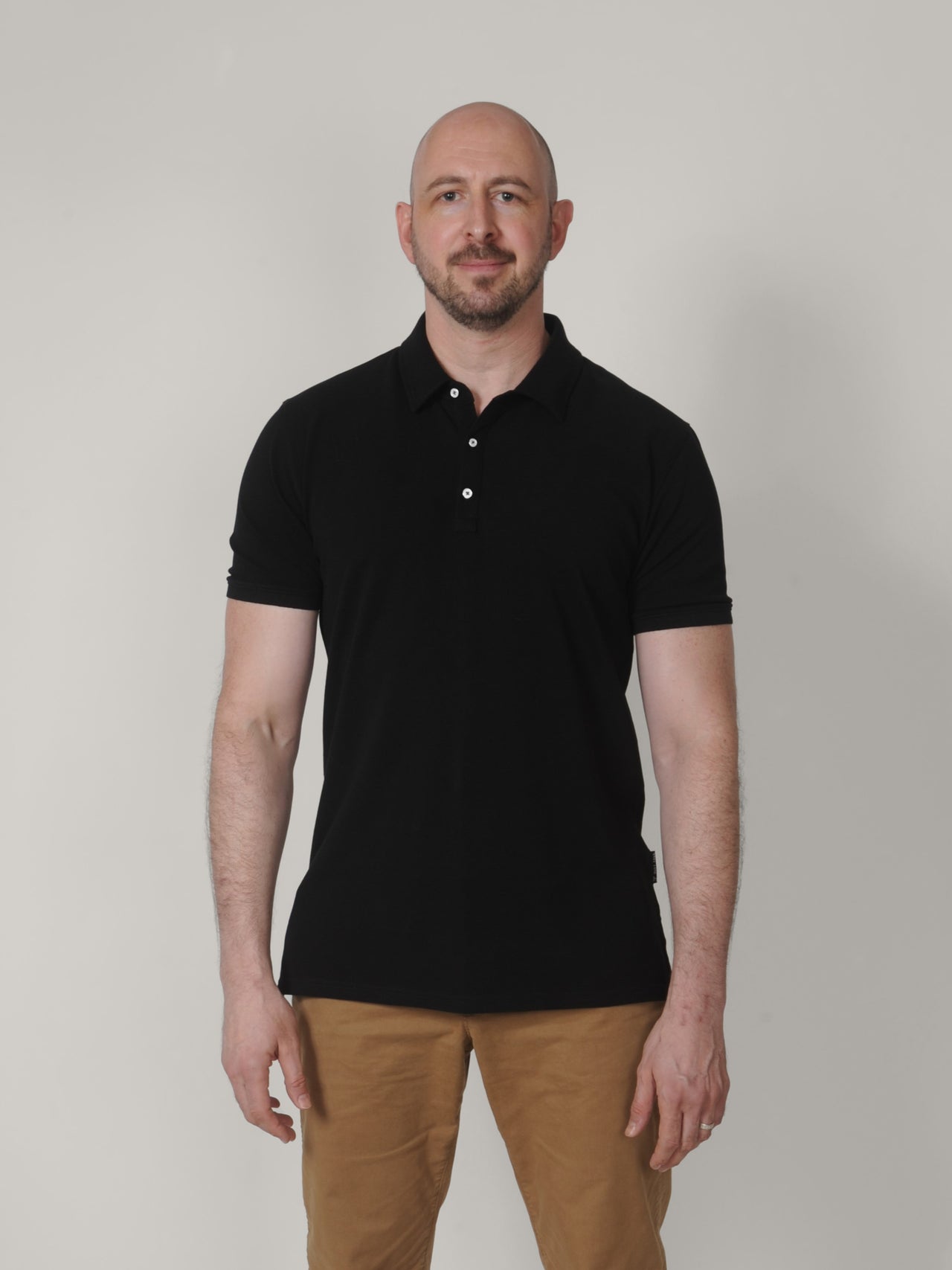 A tall slim guy wearing a black XL tall polo shirt.