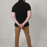 A shot from behind of a tall skinny guy wearing a XL tall black pique polo shirt.