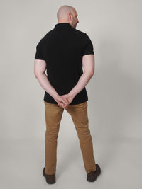 Thumbnail for A shot from behind of a tall skinny guy wearing a XL tall black pique polo shirt.