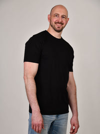 Thumbnail for A tall and slim guy in the studio wearing a black XL tall slim t-shirt.