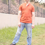 A tall skinny guy wearing a tall brown henley shirt and smiling.