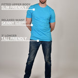 A head to toe shot of a tall athletic guy wearing a cyan XL tall t-shirt and smiling.