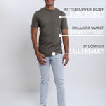 A head to toe shot of a tall slim guy wearing a dark grey medium tall t-shirt.